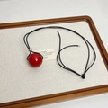 Macro detail of red sphere pendant with black cord and silver beads on a white tray - Glossy Red Ball Pendant (Z-3125)