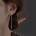 Detail of silver S925 long tassel earrings with Z-shaped charm on female model - Letter Z