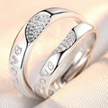 Macro shot of silver-plated couple rings with 'love' engraving and crystals on silk - Cherish Each Other
