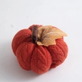 Macro shot of orange knitted pumpkin ornament with fabric leaf detail for autumn decor - Orange
