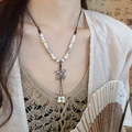 Détail du collier papillon en céramique vintage avec pompons et corde tissée - Papillon Blanc Cassé