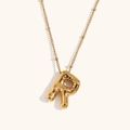 Detailed macro view of 18K gold plated balloon R letter pendant on a beaded chain - Gold-R