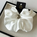 Macro view of oversized white satin scrunchie with silk luster on a linen tray - 18cm / White