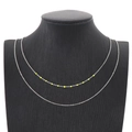 Double-layered silver steel necklace with vibrant neon yellow bead accents on black display - Yellow