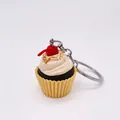 Detailansicht eines Cupcake-Schlüsselanhängers mit gelber Basis und weißer Sahnehaube - Eiscreme