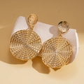 Dettaglio di orecchini geometrici dorati con texture martellata e motivo intrecciato - Perno in acciaio inossidabile - Oro