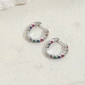 Silver-toned hoop earrings with colorful zircon stones on a white stone background - Small Multicolor Zirconia White Gold Style (ES2223)