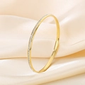 Macro detail of gold-plated titanium steel bangle with shimmering zircon stones on silk - 64*4mm(KB98517-K)