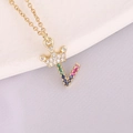 Macro shot of 18K gold crown initial V pendant with colorful micro-pave zircons - Style Letter V