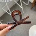 Primo piano di una pinza per capelli a fiocco marrone scuro semitrasparente in resina - Rosso Marrone Lucido