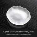 Pink frosted glacier-style crystal glass coaster with irregular edges on a wooden table - Liuli White (Mat)