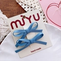 Close-up of handmade blue satin ribbon bow hair clips on white display card - Aqua