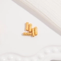 Detailansicht von fünf goldenen S925-Silber-Zylinderperlen mit Rautenmuster auf weißem Tuch - Gold / Klein 2x6mm / Gittermuster