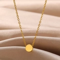 Vue macro d'un collier pendentif circulaire en or poli sur un tissu en soie - Style Rond
