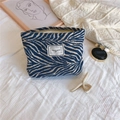 Detail van chenille make-uptas met blauw zebramotief en geweven label bovenaan - Blauw