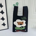 Black knitted tote bag featuring a cute cartoon bear and white flower pattern design - Black Floral