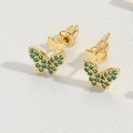 Detailed macro view of golden butterfly stud earrings with sparkling green zircon inlays - Butterfly / Gold/Green Zirconia