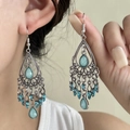 Bohemian vintage drop earrings with blue gems and silver tassels on a female model - Silver/Blue