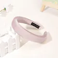 Detail of light pink satin headband featuring a black 'Hand Made' woven inner label - Pink