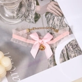 Sweet pink lace choker with a silk bow and golden bell on a lifestyle magazine background - Pink Lace Bowknot Neck Bell Choker