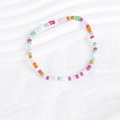 Close-up of colorful Bohemian seed bead bracelets on a clean white textured background - Colorful