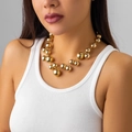Close-up of punk style golden beaded necklace with high-shine polished metallic finish - Gold