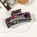 Close-up of black rectangular hair claw clip with colorful heart prints and glossy finish - 8.5cm Heart Print - Style C Black Base