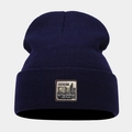 Detailed view of dark blue knit beanie featuring a vintage Denim Supplies logo patch - One Size / Navy Blue