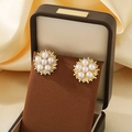 Golden sunflower earrings with central pearls displayed in a brown jewelry box - Gold Sunflower Style (KE119631-SP)
