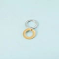 Pendaglio d'oro e anello portachiavi d'argento in acciaio su sfondo blu chiaro - Oro