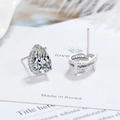 Silver pear-cut zircon stud earrings on a white card with soft feather background - White Zirconia
