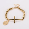 Detalle de pulsera de cuentas doradas con medalla de San Benito y colgante de cruz - Dorado