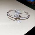 Detailed macro view of silver flower bracelet with zircon stones and a white pearl - Silver-Transparent Butterfly