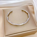 Close-up of silver bamboo joint textured steel bracelet on white silk in a jewelry box - Steel Color (P318)