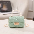 Mini mint green jelly bag with pearl handle and quilted texture on marble surface - Green