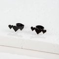 Close-up of triple heart-shaped black stud earrings on a textured stone surface - 099 Triple Heart / Black