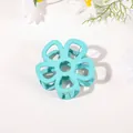 Macro shot of mint green flower hair claw clip with matte finish and silver spring detail - Hollow Five-Petal Flower - Matte Blue