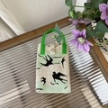Détail du sac tricoté avec motif d'oiseau, poignée verte et fermoir métallique à pression - Hirondelle Noire - Sac de Téléphone