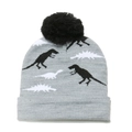 Detailed close-up of knit fabric showing grey dinosaur patterns and black pom-pom on winter hat - Gray