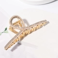 Detail of a gold hair claw clip adorned with shimmering pearls and sparkling rhinestones - Cross Rhinestone Gold