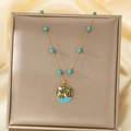 Detailed close-up of a gold tropical necklace featuring a coconut tree and turquoise beads - Turquoise Beaded Tropical Island Style (KN292168-SXSJ)