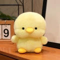 Soft yellow chick plush toy with fluffy fur and cute orange beak on a wooden desk - Yellow Duck / 15CM