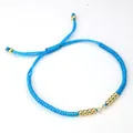 Adjustable bright blue braided rope bracelet featuring gold beads and a sliding knot - Blue