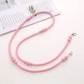 Detailed close-up of pink acrylic beaded crossbody chain with metal lobster clasps on a magazine - Acrylic Beaded (K1281) / Pink