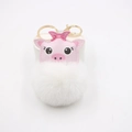 Dettaglio di testa di maiale in pelle rosa e pompon bianco su un portachiavi in metallo oro - Bianco