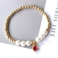 Close-up of pearl bead bracelet with a red heart pendant and gold metallic beads - Style 5 (Heart)