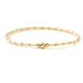 Minimalistisches Armband aus cremefarbenen Perlen mit goldenen Akzenten auf Weiß - Creme