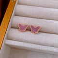 Detail of rose gold butterfly earrings with purple shell inlay on beige fabric base - Purple Butterfly Style