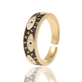 Nahaufnahme eines goldenen offenen Rings mit schwarzen Emaille-Augen und weißen Punkten - Schwarz