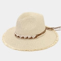 Detailed view of beige straw hat featuring woven bands and fringe tassels on the brim - One Size / Beige